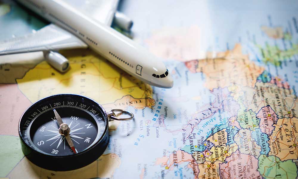 selective focus miniature tourist compass map with plastic toy airplane abstract background travel concept - خدمات مهاجرتی چین